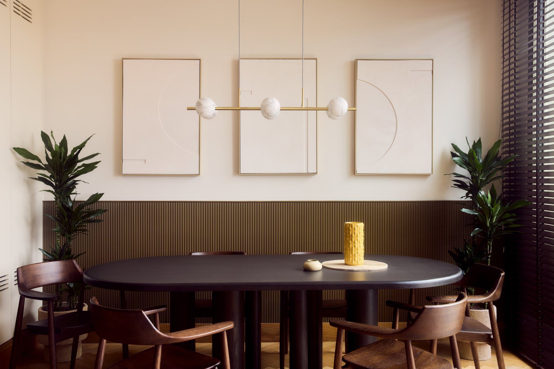 A dining room designed by Matt Smith-Wood, with fluted panelling and a brass pendant, Lisbon