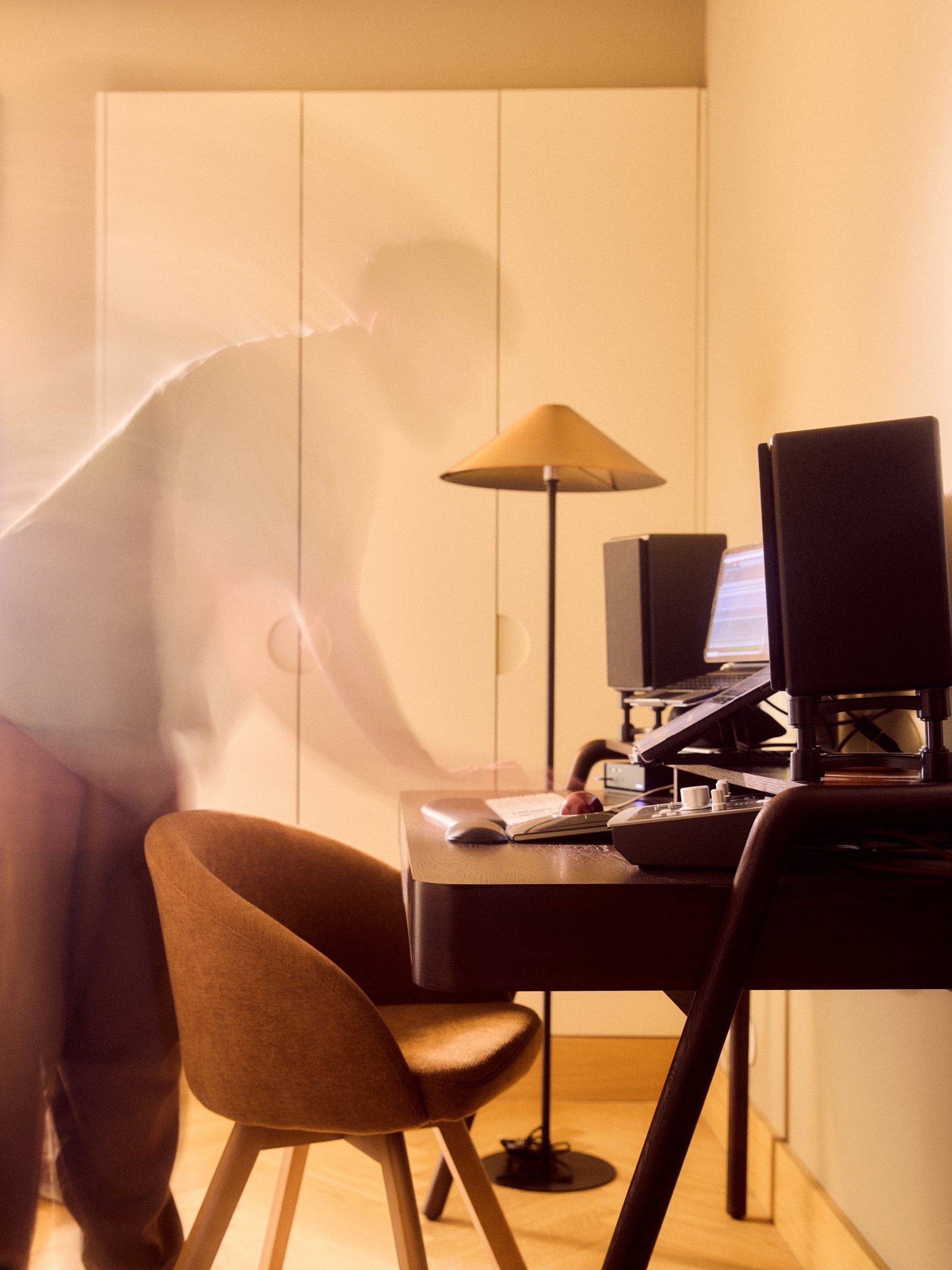 Matt Smith-Wood at the desk in the finished flat, caught mid-movement