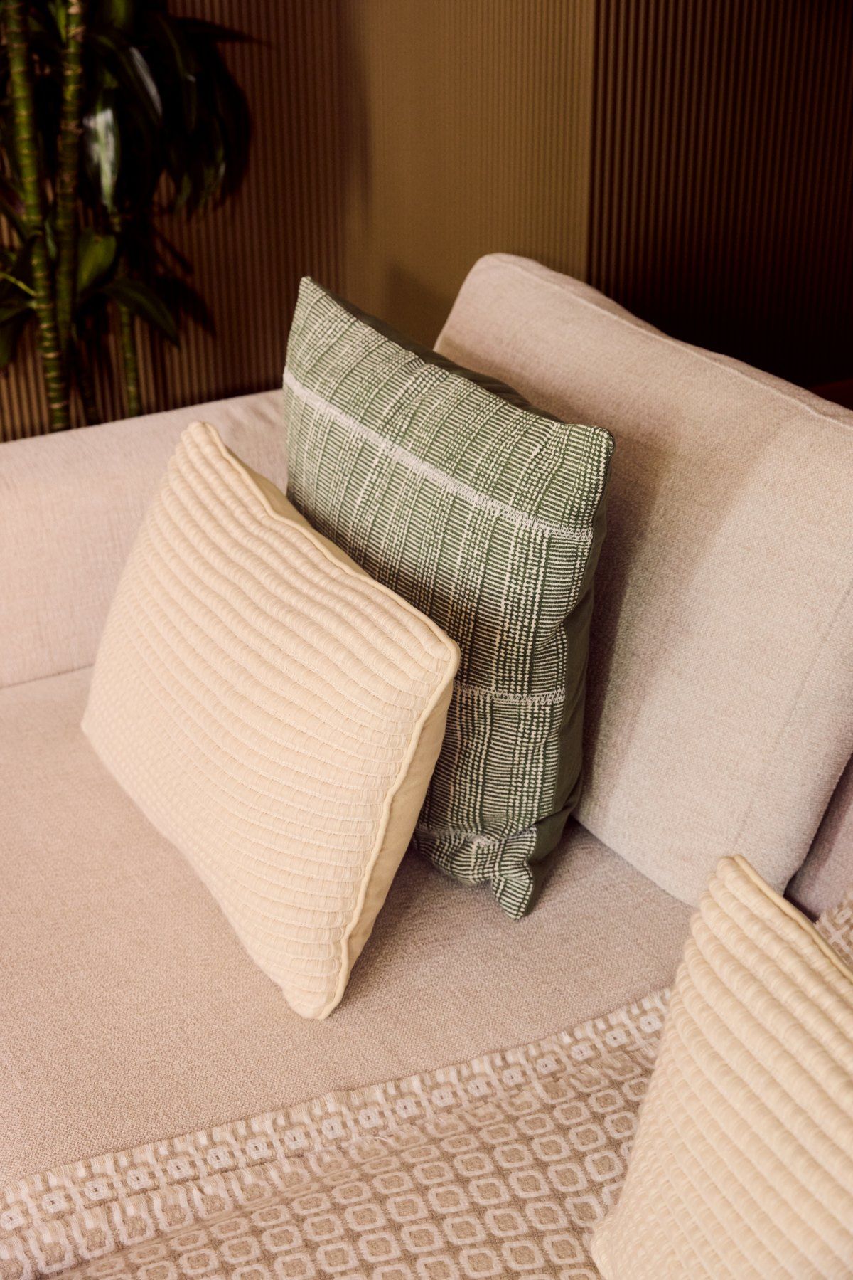 Cushions in linen and sage against a boucle sofa