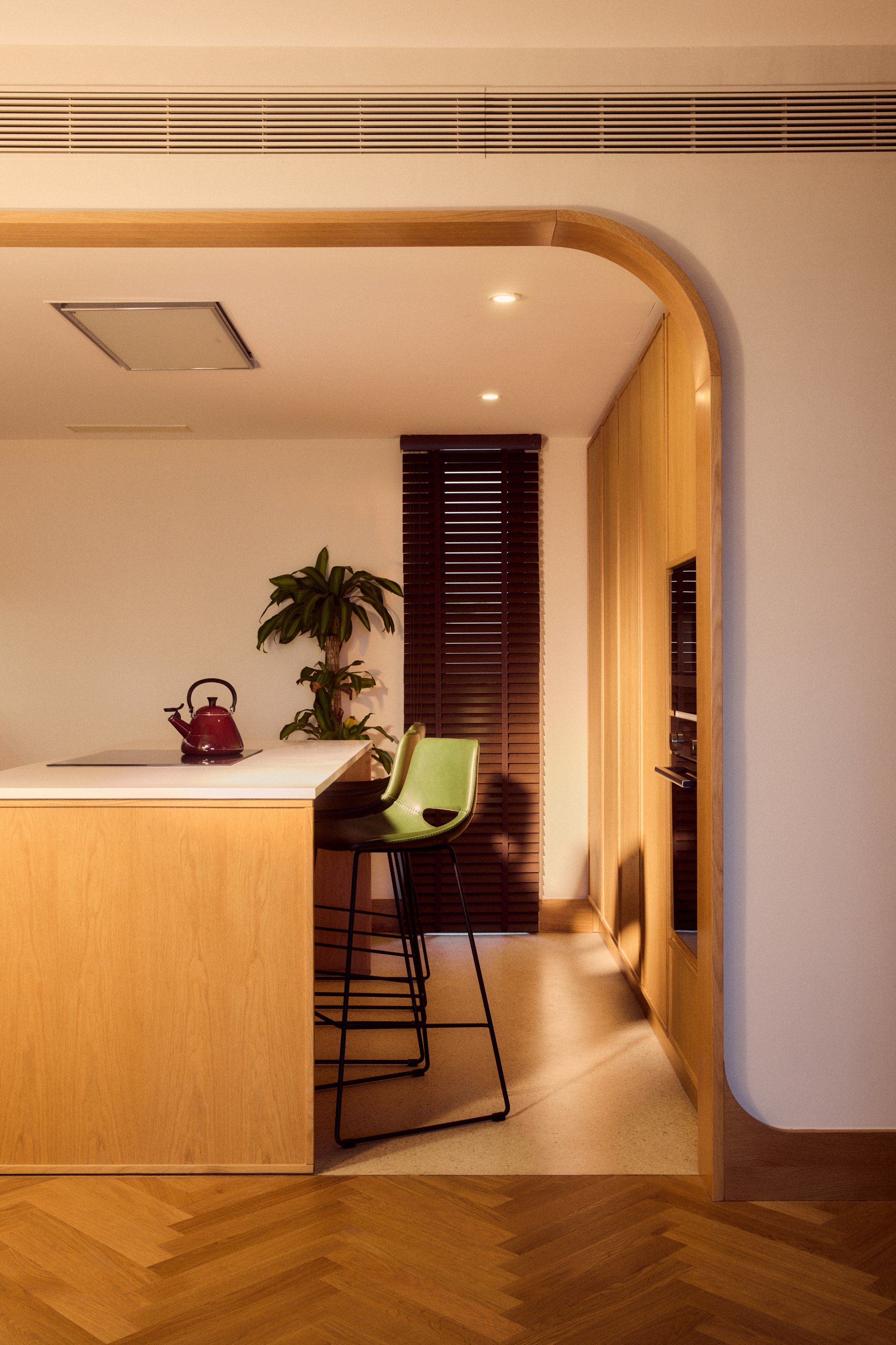 Looking through an arched opening from the hall into the kitchen