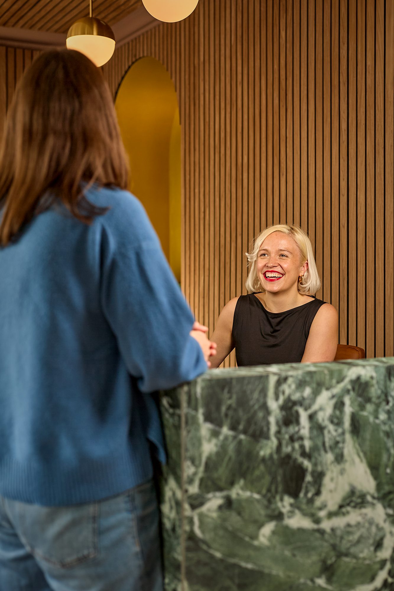 A patient arriving and being greeted at the reception desk