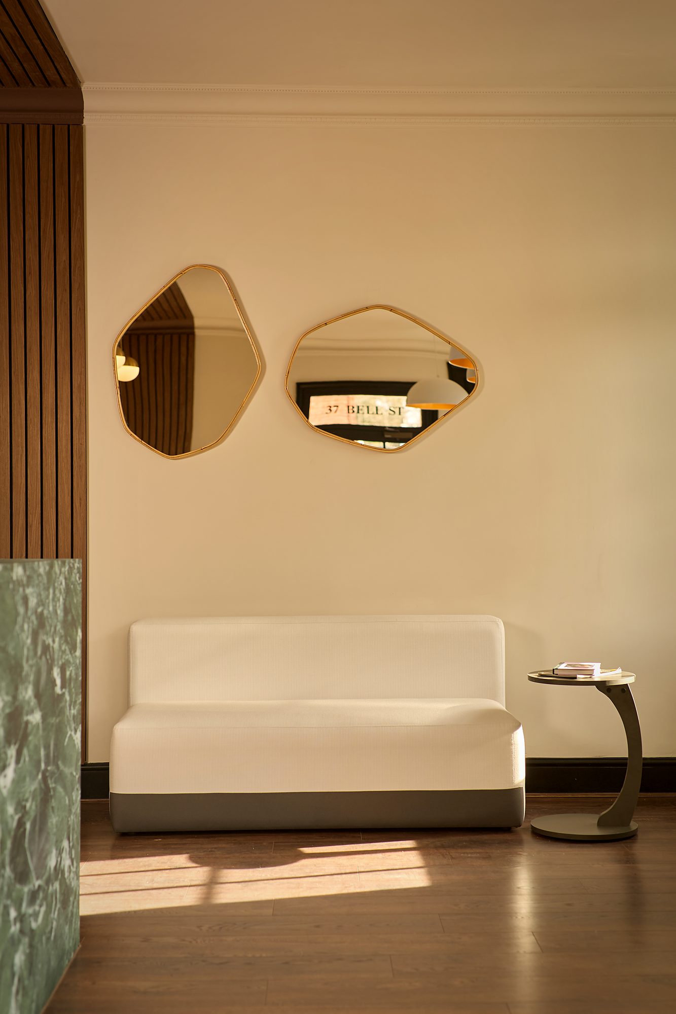 The two mirrors as built, hung on plaster beside the fluted oak and a green marble jamb