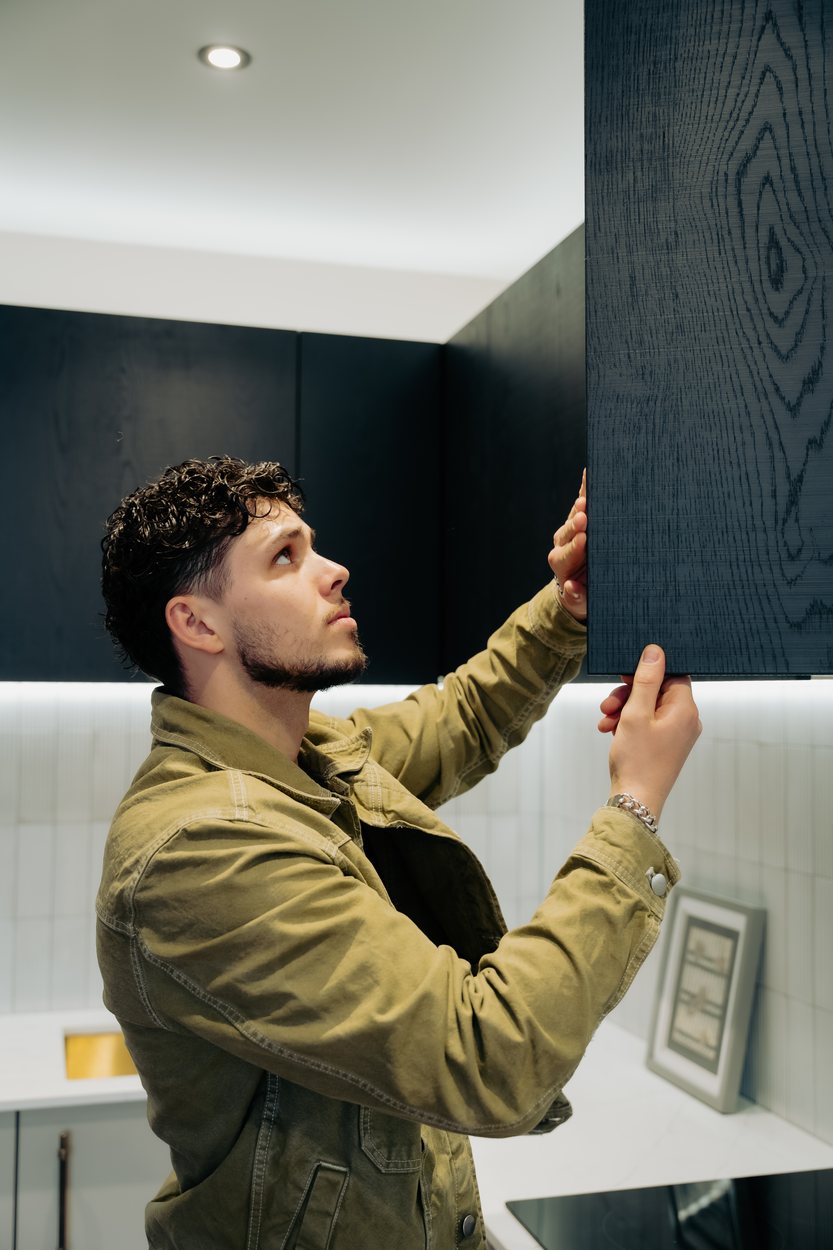 Matt Smith-Wood holding a dark oak sample door against a fitted kitchen, London